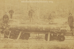 Cadillac-Lumber-Lumberjacks-loading-logs-into-railroad-car-with-a-light-snow-on-the-logs